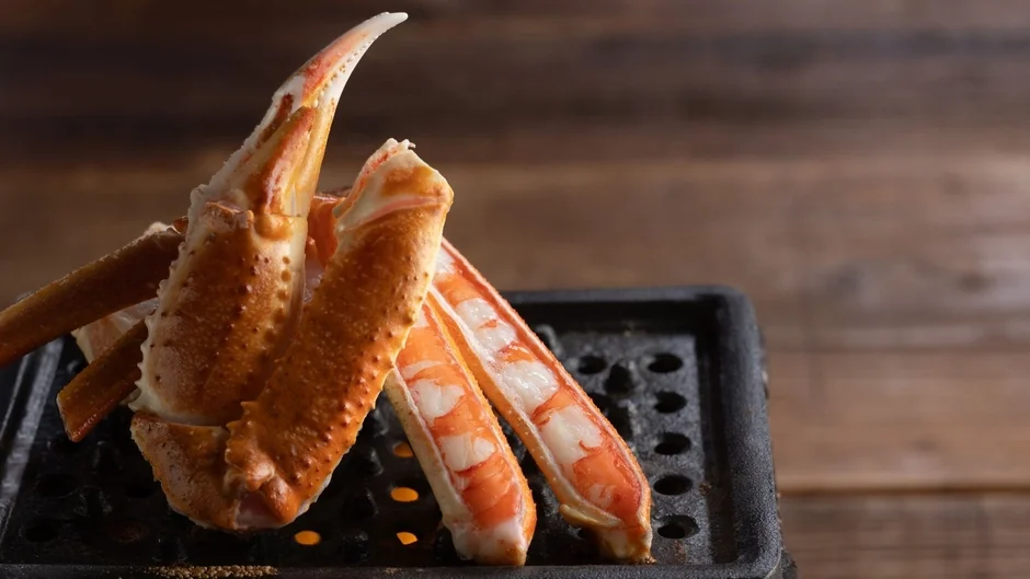 網の上で焼かれるカニの脚