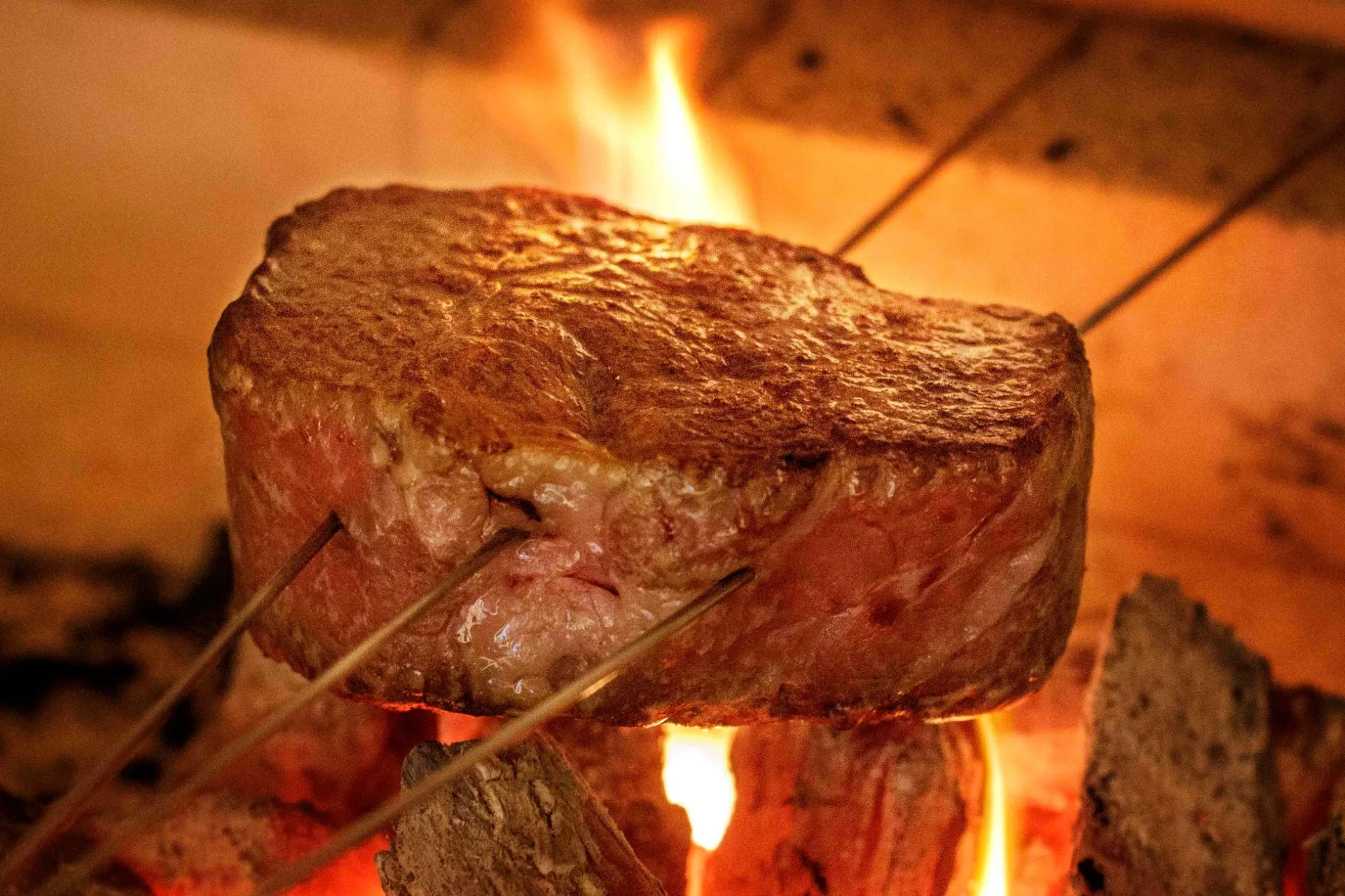 薪火でじっくりと焼かれる分厚いステーキ