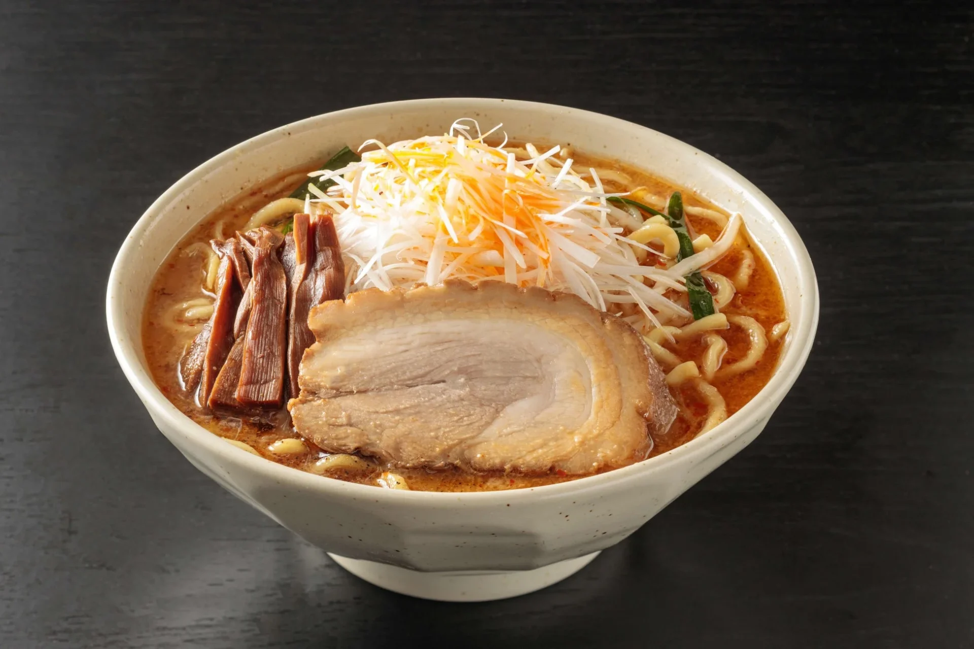 チャーシュー、メンマ、白髪ネギがたっぷり盛られた味噌ラーメンのような麺料理