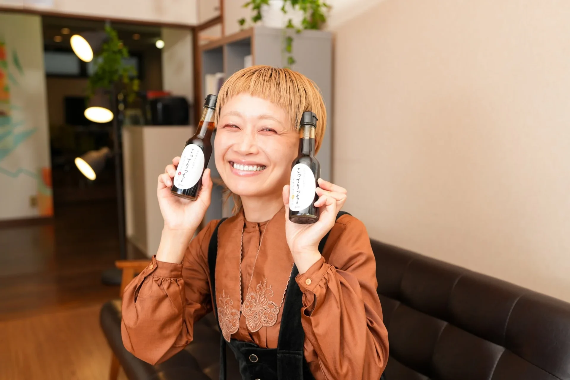 イベントで「こってりつゆ」のボトルを持つロシアン佐藤さん