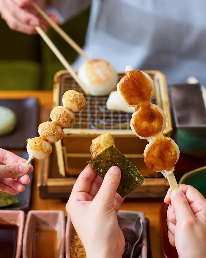 きな粉やみたらし団子、海苔を巻いた餅を囲んで楽しむ様子